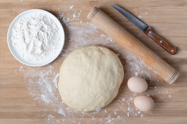 istock Top view of dough and baking ingredients on wooden table 1293513932