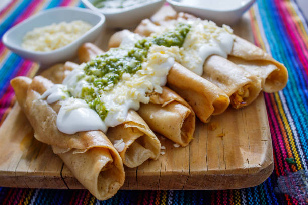 tacos di pollo fritti messicani con crema messicana e salsa verde - smetana foto e immagini stock