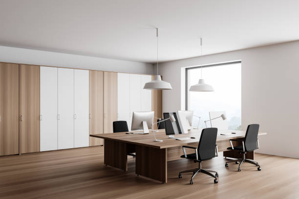 istock White and wooden open space office corner with windows 1293516630