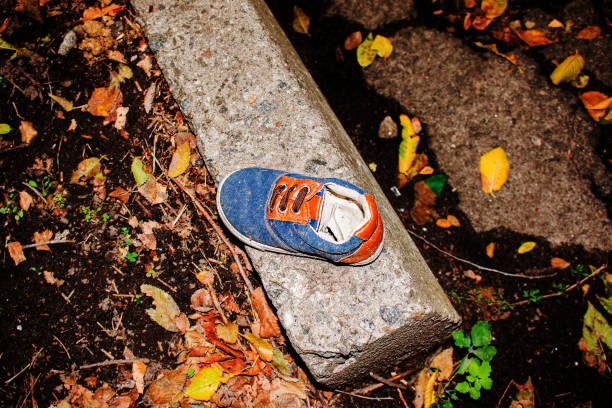 istock Old children's sneaker near the gutter. Ecology concept. 1293517493
