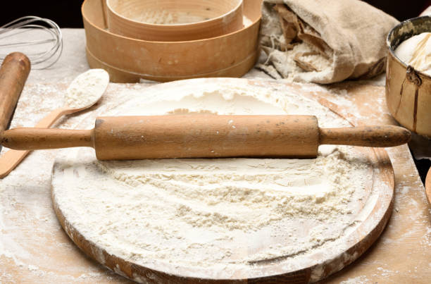 istock white wheat flour and wooden rolling pin on board, baking ingredients 1293519866