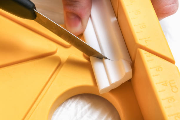 The man cuts off the molding cornice on miter box. The man cuts off the molding cornice on the miter box. architectural cornice stock pictures, royalty-free photos & images