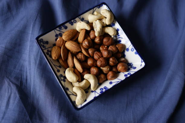 Istanbul, Turkey-December 28, 2020: A Plate of Nuts on a Blue Cover. Full frame, Studio shot, Flat lay.