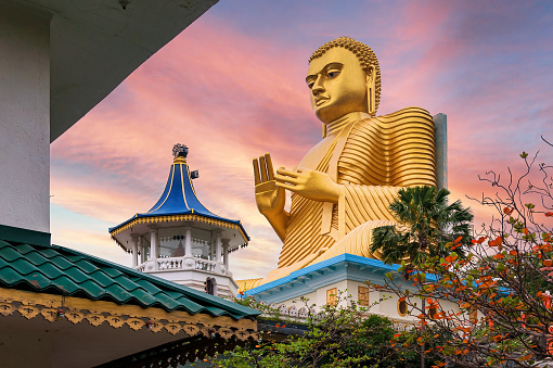 Golden Buddha statue in Dambulla Temple in Sri Lanka at sunset