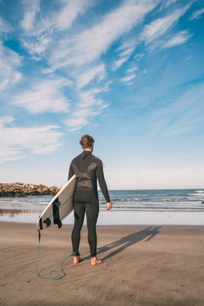 istock Surfer entering into the water with his surfboard. 1293527114