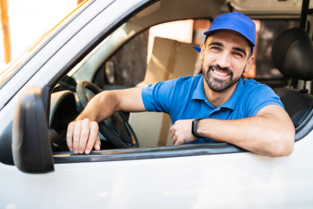 istock Delivery man driving van with cardboard boxes on seat. 1293527141