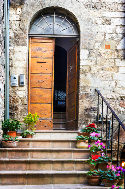 Flowers in pots on the stone steps medieval house in Assisi, Italy