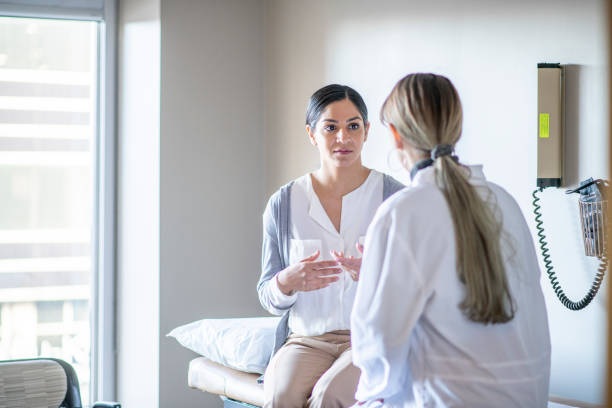 paciente femenina en el consultorio del médico - visita fotografías e imágenes de stock