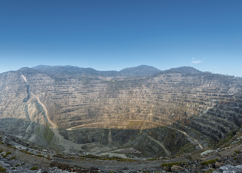 open pit iron mine against a blue sky