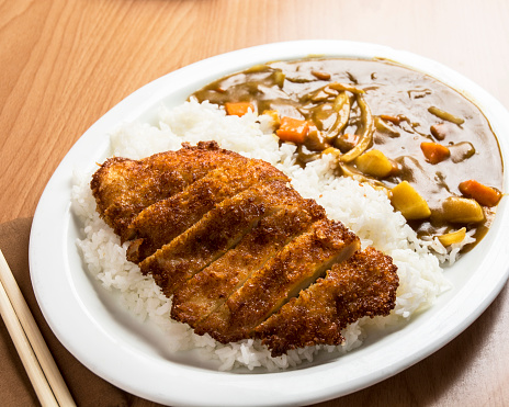 Picture of homemade menu: egg fried rice topped with fried chicken on a plate at a dining table