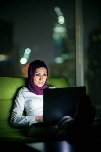 istock Young Muslim woman using laptop at night 1293536817