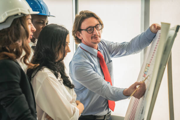 istock architecture and engineering business background of architect and engineer project development team brainstorming together with commercial tower floor plan board in architect office 1293543794