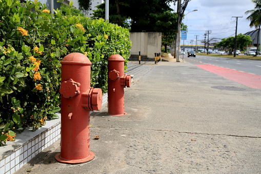 Lonely red fire hydrant stands out amidst the gray and industrial surroundings of Medellin, Colombia.