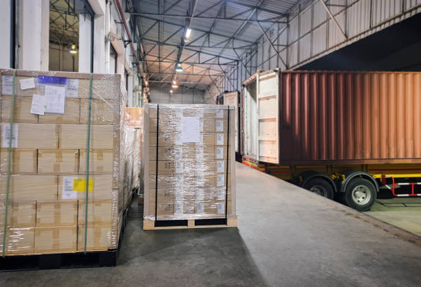 istock Stacked of package boxes wrapping plastic on pallet waiting to load into shipping container. Cargo shipment boxes, Freight truck, Warehousing. Logistics and transportation. 1293546633