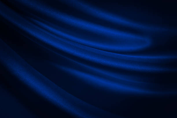 istock Black blue abstract background. Dark blue silk satin texture background. Shiny fabric with wavy soft pleats. 1293552879