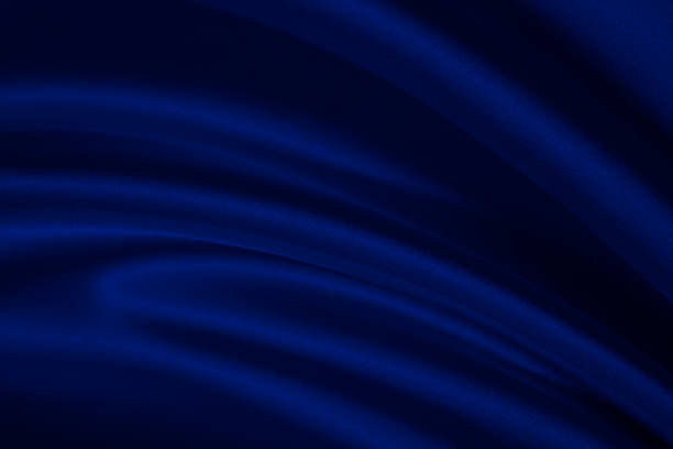 istock Black blue abstract background. Dark blue silk satin texture background. Shiny fabric with wavy soft pleats. 1293552883
