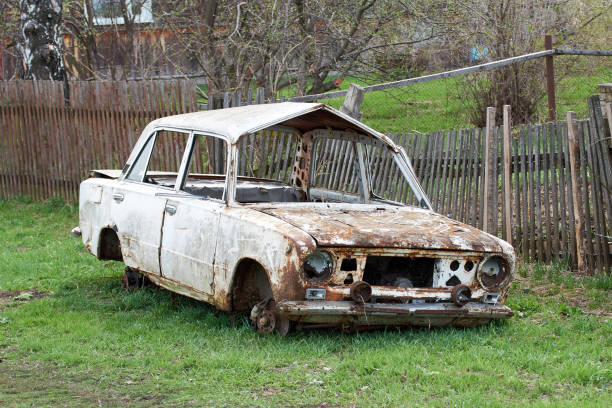 Old abandoned rusty vehicles, crushed cars in scrapyard, junk yard needed to be utilised and reused to protect nature and environment, metal recycling concept.