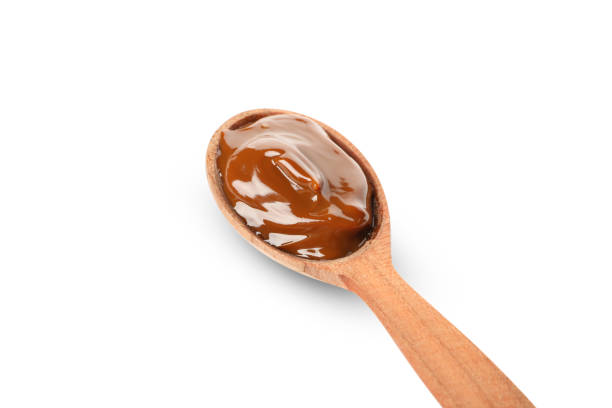istock Spoon with caramel condensed milk isolated on white background 1293560692