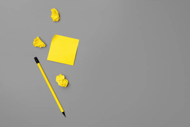 istock Yellow adhesive notes and pen on gray background 1293563703
