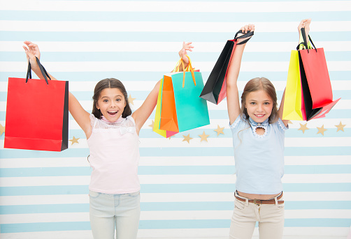 Black friday coming. Kids girls children with packages after shopping day. Girls friends happy carry paper bags. Best discount promo code. Black friday shopping great opportunity profitable purchase.