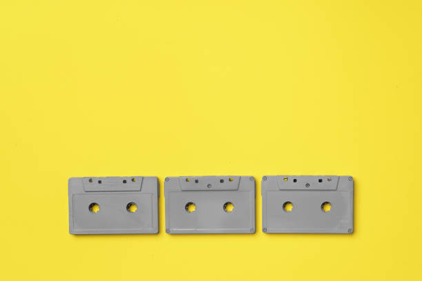 istock Gray audio cassette on yellow background top view 1293564381