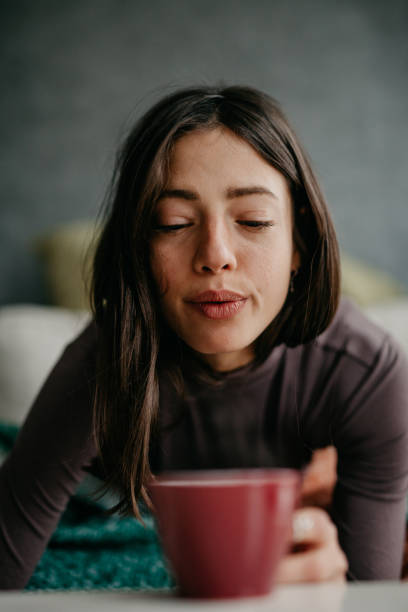 istock Beautiful female blowing into a her coffee 1293565431