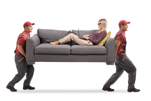 istock Movers carrying a woman on a sofa with a laptop computer 1293569553