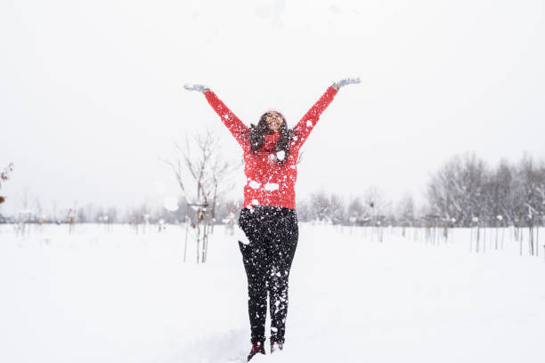 istock young beautiful woman playing with snow 1293571041