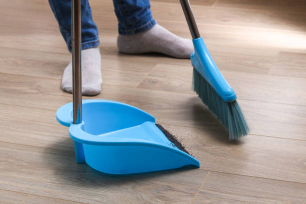 istock The man sweeps the debris into a blue scoop with brush. 1293572248