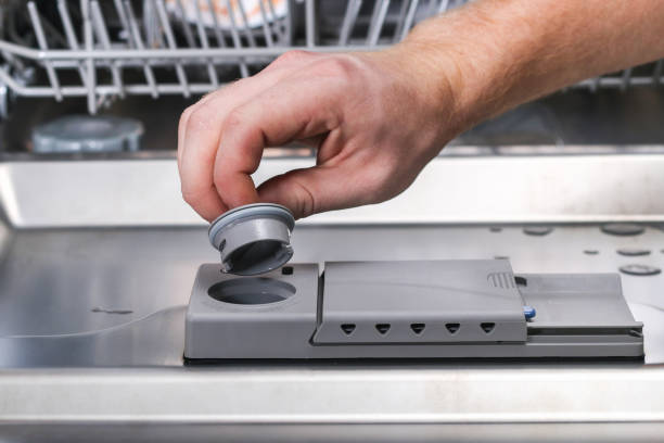 istock A man pours a rinse aid into dishwasher compartment. 1293572256