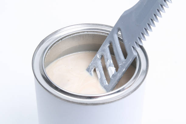 istock A man stirring white paint in can on white background. Renovation concept. 1293572290