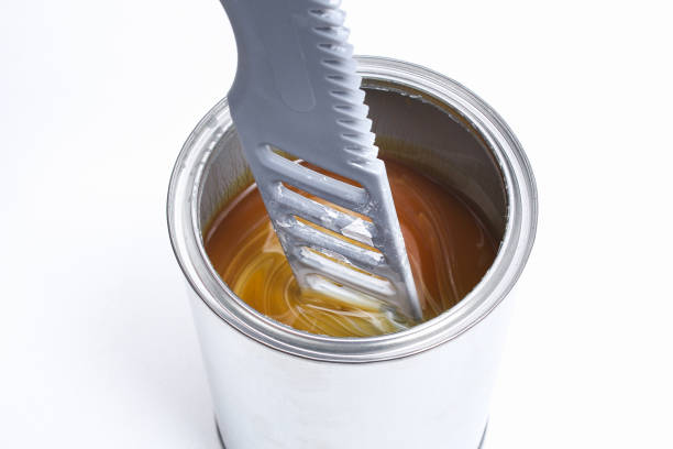 istock A man stirring white paint in can on white background. Renovation concept. 1293572293