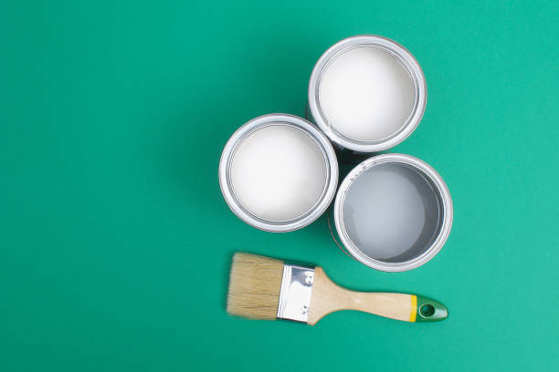 istock Open paint enamel cans on green turquoise palette samples. 1293572314