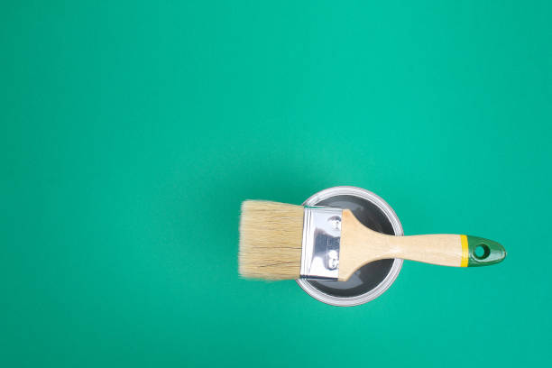 istock Open paint enamel cans on green turquoise palette samples. 1293572323