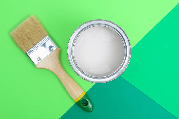 istock Open paint enamel cans on green palette samples. 1293572333