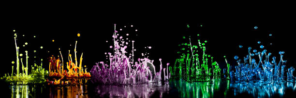 dancing colored water drops on black background stock photo