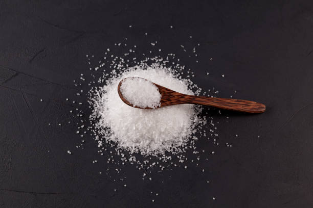 istock Glutamic acid monosodium salt on dark background. Msg or Food additive E621 in wooden spoon, top view. Selective focus, copy space. The additive is used in food industry 1293580667