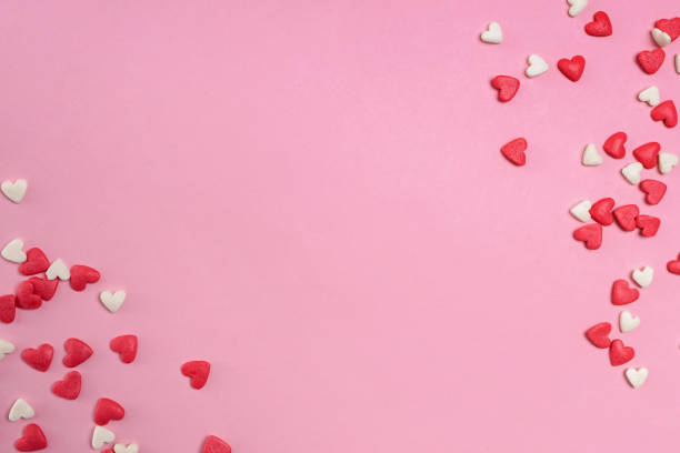 istock Sugar heart shaped sprinkles on pastel pink background 1293585989