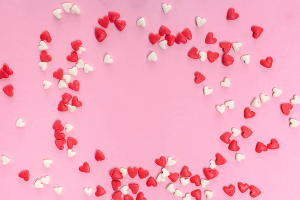 istock Sugar heart shaped sprinkles on pastel pink background 1293585998