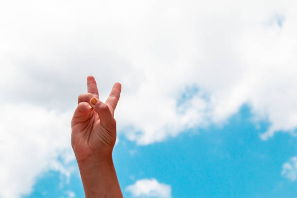 hands making the freedom sign with their hands raised to the sky