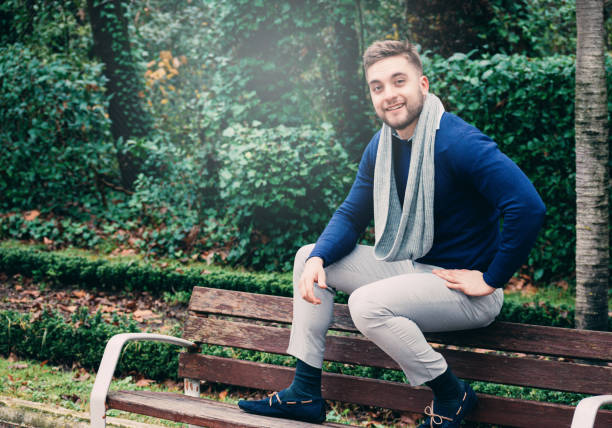 istock young man sitting on a bench looking at camera 1293589462