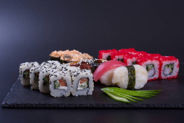 istock Colorful rolls with seafood and rice lie on a dark stone background 1293590574