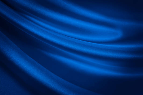 istock Black blue abstract background. Dark blue silk satin fabric texture background. Liquid wave effect 1293590594