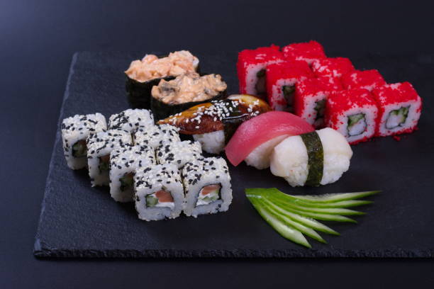 istock Colorful rolls with seafood and rice lie on a dark stone background 1293590615