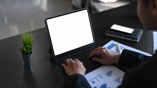 istock Close up view of businessman working at office with tablet computer and documents on his desk. 1293592204