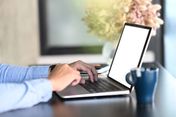 istock Side view man hands typing on keyboard of mock up laptop computer with blank screen. 1293592304