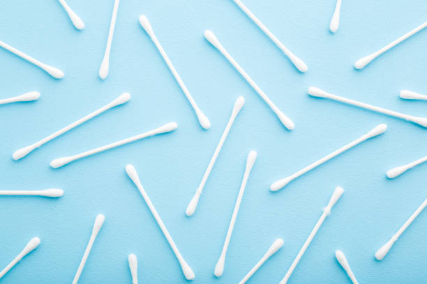 White sticks of cotton bud on light blue table background. Pastel color. Closeup. Top down view. White sticks of cotton bud on light blue table background. Pastel color. Closeup. Top down view. cotton swab photos stock pictures, royalty-free photos & images
