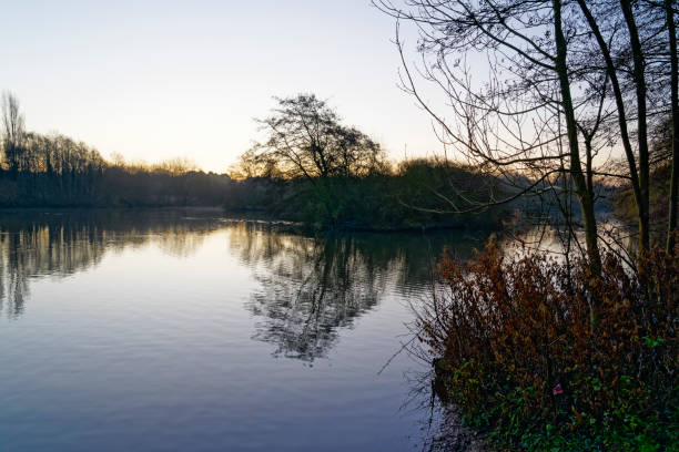 istock Low winter sun begins to rise over a misty lake 1293595600
