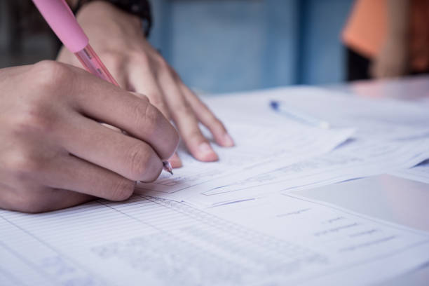istock Hands Student testing in exam on exercise taking at high school or university in test room. Writing document exams at campus classroom, back to school and evaluation measurement in education 1293595635