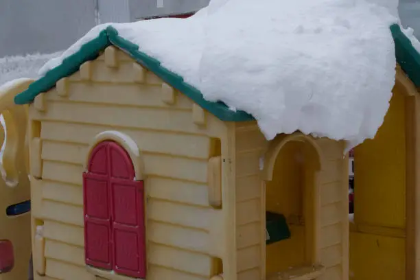 thermal insulation in modern building in winter, snow covered yellow toy house